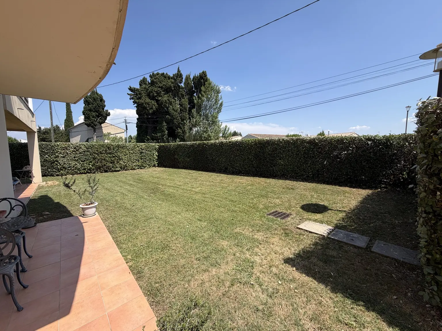 Pelouse tondue et haies taillées autour d’un jardin